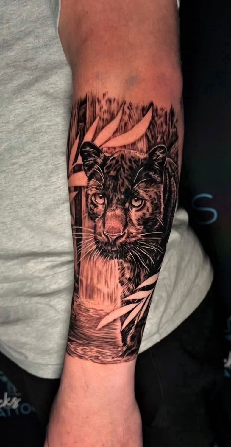 Black and grey panther and waterfall realism tattoo