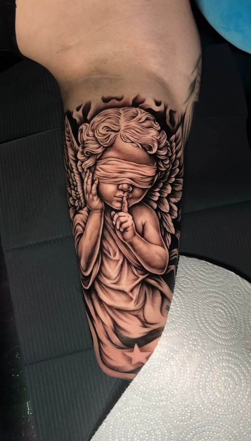 Black and grey blindfolded cherub angel tattoo