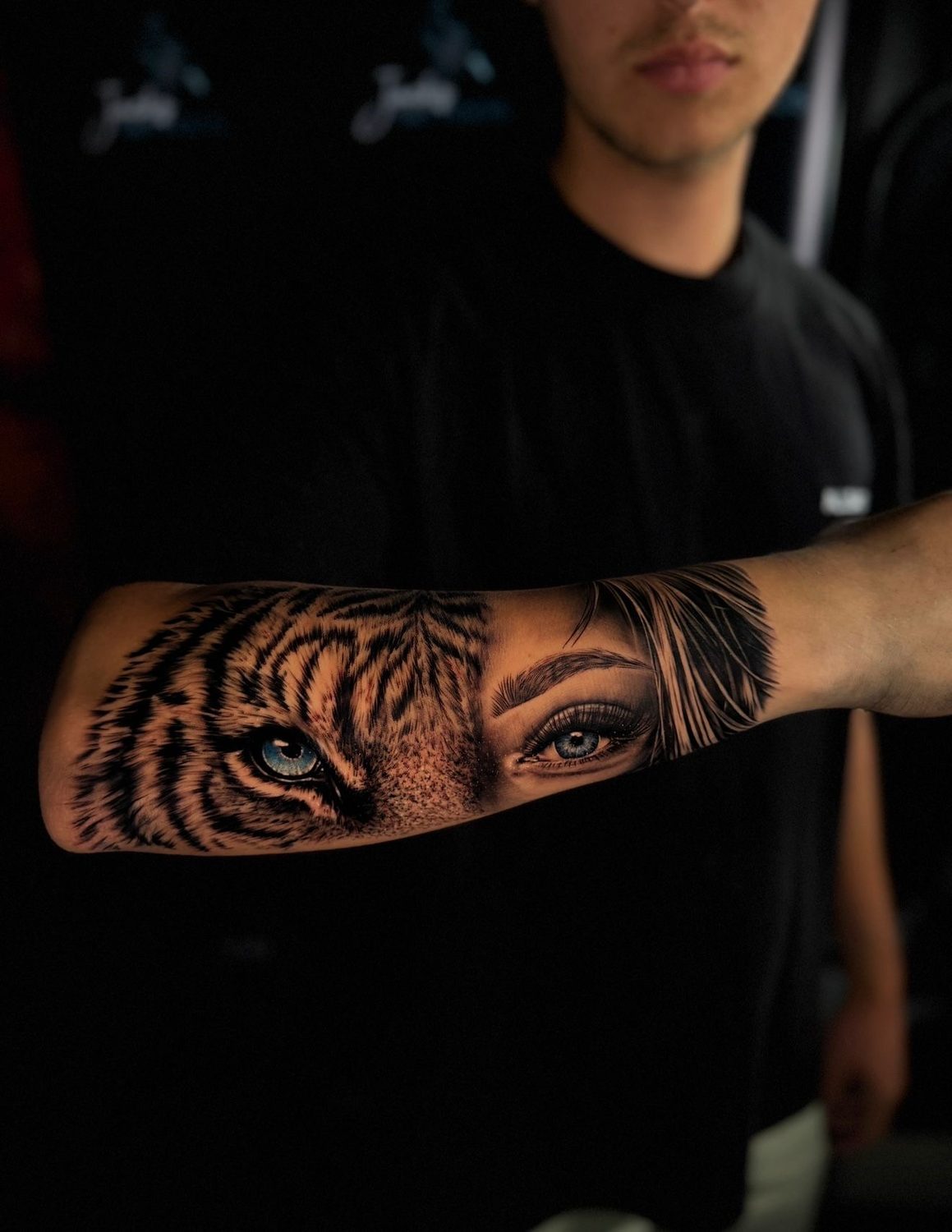 Black and grey realism tiger eye and woman eye forearm tattoo